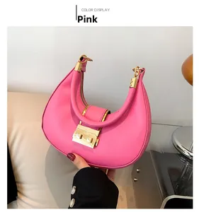 Detail of pink crescent bag with golden clasp and zipper closure in hand