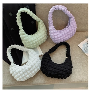 Close-up of textured bubble fabric shoulder bags in green, purple, white and black colors
