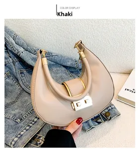 Close-up of khaki half-moon bag featuring smooth leather and gold metal twist-lock