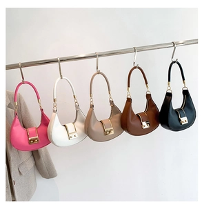 Five trendy hobo bags in pink, white, khaki, brown, and black displayed on a metal rod