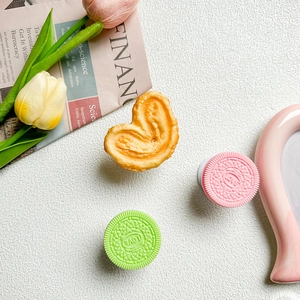 Close-up of heart-engraved cookie shaped phone grip sockets in pink and green
