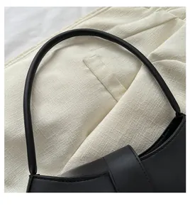 Macro detail of high-quality black leather shoulder bag handle and stitching texture