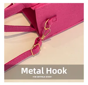 Détail macro du crochet doré et de l'anneau en D sur un sac à main en feutre rose