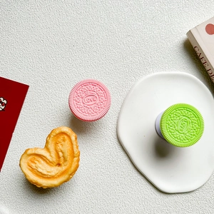 Close-up of cute cookie-shaped and love-printed expandable phone grip sockets