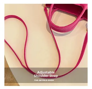 Détail macro du sac en feutre rose avec crochets dorés et bandoulière réglable