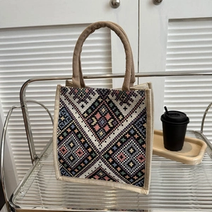 Vintage ethnic tote bag with geometric embroidery and jute handles on a shelf