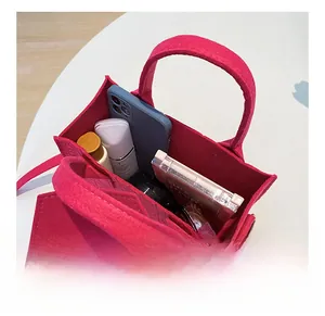 Vue détaillée montrant l'espace intérieur du sac fourre-tout en feutre magenta pour objets