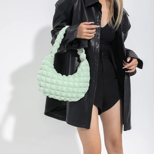 Chic mint green hobo cloud bag with textured bubble fabric shown on model shoulder
