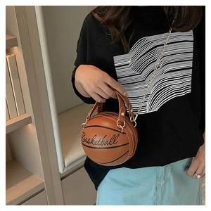 Detail of round basketball shaped crossbody bag with gold chain strap and letter print