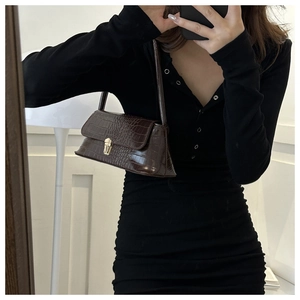 Selfie allo specchio con borsa baguette marrone scuro con motivo coccodrillo e fibbia