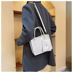 Détail du sac à main blanc gaufré avec mini pochette et garnitures dorées