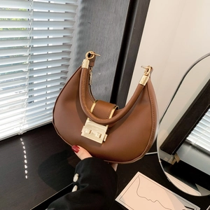 Brown leather crescent shoulder bag with golden buckle and minimalist vintage design