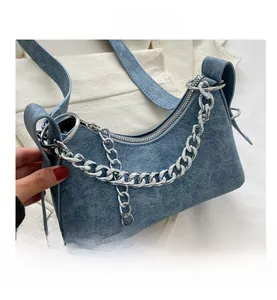 Detail shot of the denim texture crescent bag with stylish silver chunky metal chain strap