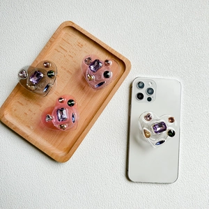 Luxury heart-shaped phone socket grip with colorful gemstones in various pastel colors
