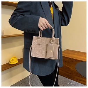 Détail d'un sac à main en cuir gaufré avec porte-monnaie assorti et bandoulière amovible
