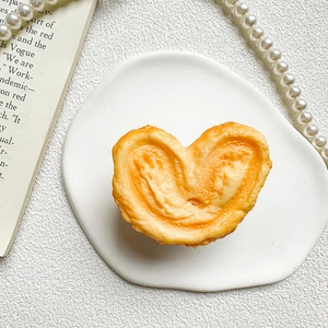Macro shot of realistic palmier biscuit phone grip on a white plate with elegant decor