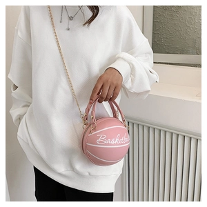 Dettaglio di una borsa a tracolla rosa a forma di basket con catena d'oro e scritte bianche