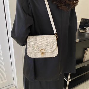 Women's cream straw saddle bag with floral embroidery and golden horseshoe clasp