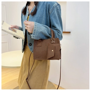 Détail du sac à main en similicuir marron avec gaufrage circulaire et mini porte-monnaie