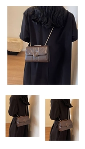 Detail of a dark brown quilted leather crossbody bag with a vintage round metal buckle