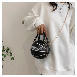Détail du sac noir en forme de basket avec lettrage blanc et chaîne en métal doré
