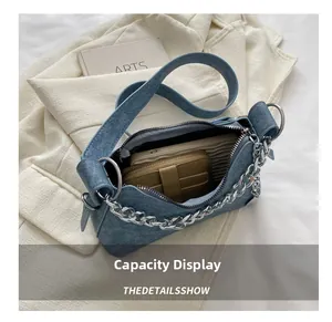 Blue denim crossbody bag capacity display showing phone and wallet with metal chain detail