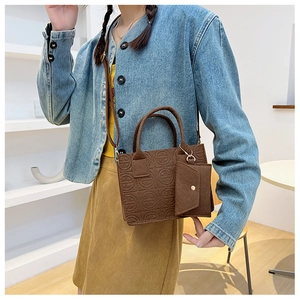 Détail du sac en feutre marron foncé avec matelassage rond et mini pochette attachée
