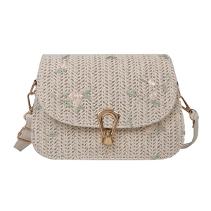 Beige straw woven saddle bag with delicate pink floral embroidery and gold U-shaped clasp