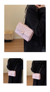 Close-up of pink chain crossbody bag featuring quilted flap design and gold hardware