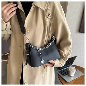 Close-up of black matte faux leather underarm bag with decorative silver chunky chain