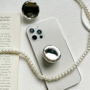 Silver diamond-cut mirror phone socket grip with pop-up ring holder on white smartphone