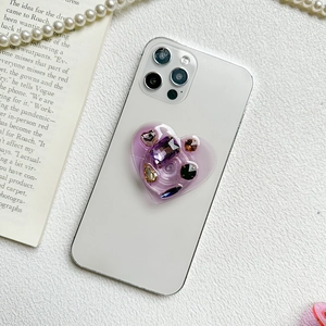 Luxury purple heart-shaped rhinestone phone grip stand shown on a white smartphone