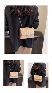 Detail of beige quilted mini crossbody bag with gold chain strap on a black blazer