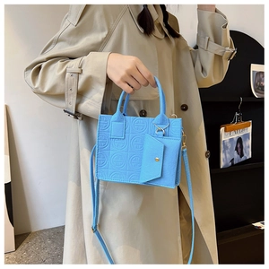 Détail d'un sac cabas en feutre bleu vif gaufré avec une petite pochette triangle assortie