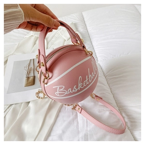 Detail shot of a pink basketball shaped handbag with gold chain strap and PU texture