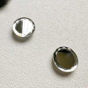 Detail of faceted crystal phone grips with diamond-cut design on textured background