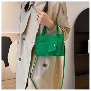 Détail d'un sac cabas vert citron gaufré avec un mini porte-monnaie assorti en accessoire