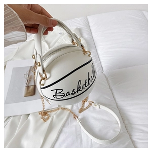 Detail of white basketball handbag featuring black cursive text and a gold chain strap