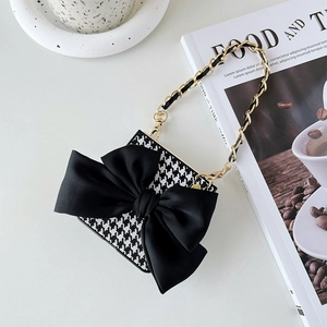 Detail of houndstooth folding phone case with black satin bow and gold chain strap