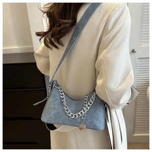 Light blue crescent bag with chunky silver chain shown on a beige wool coat outfit