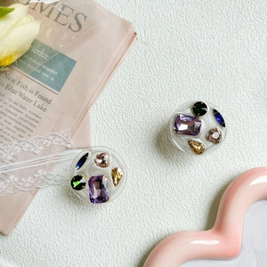 Flat lay of colorful rhinestone gem phone sockets on decorative vintage newspaper