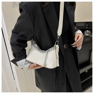 Close-up of minimalist white crescent bag with silver chain strap and wide shoulder strap