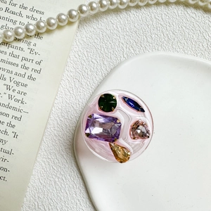 Detailed close-up of a pink resin phone grip decorated with colorful faceted gems