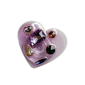 Luxurious heart-shaped phone socket grip with colorful rhinestone gems on white background