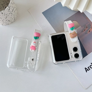 Detail of clear Z Flip case featuring a white wrist strap with 3D floral and cartoon charms