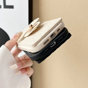 Detail of quilted leather iPhone case with crossbody chain and gold clasp wallet