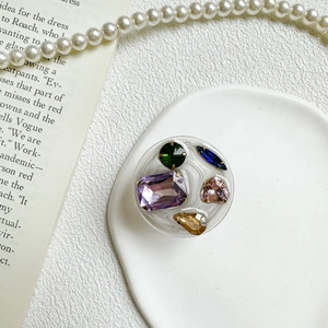 Detailed close-up of a resin phone grip featuring colorful rhinestones in retro style