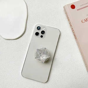 Sparkling silver glitter star-shaped expanding phone grip on white smartphone