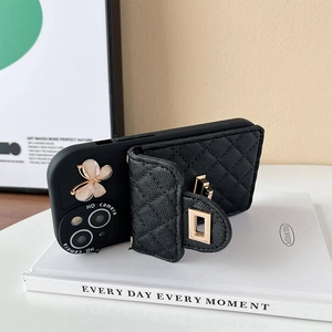 Detail of black quilted leather wallet phone case with gold butterfly and crossbody chain