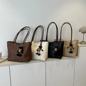 Borsa tote minimalista in ecopelle in quattro colori con cuciture e ciondolo in peluche